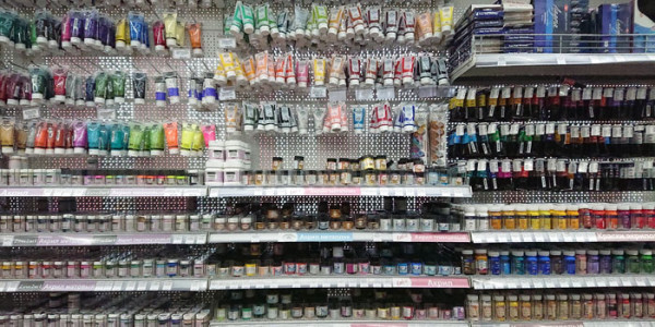 Разнообразные краски на полке в магазине для рукоделия